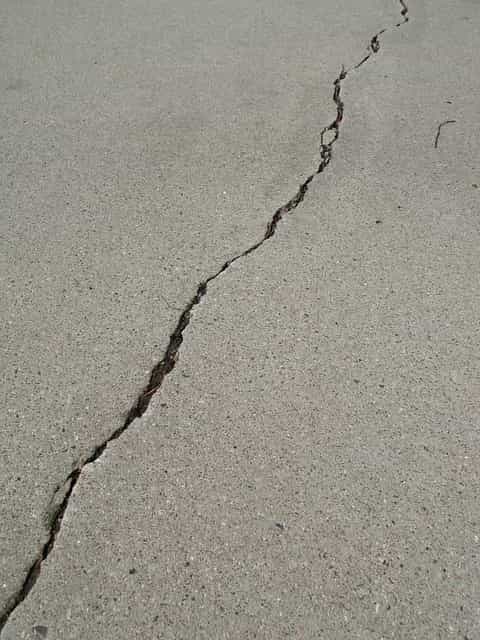 Image shows a crack along a concrete floor.